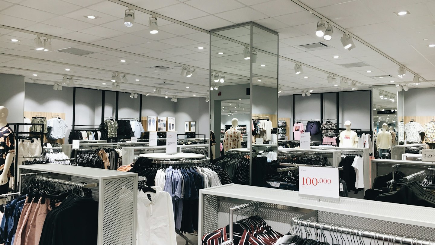 Clothing store interior with racks of garments and mannequins.