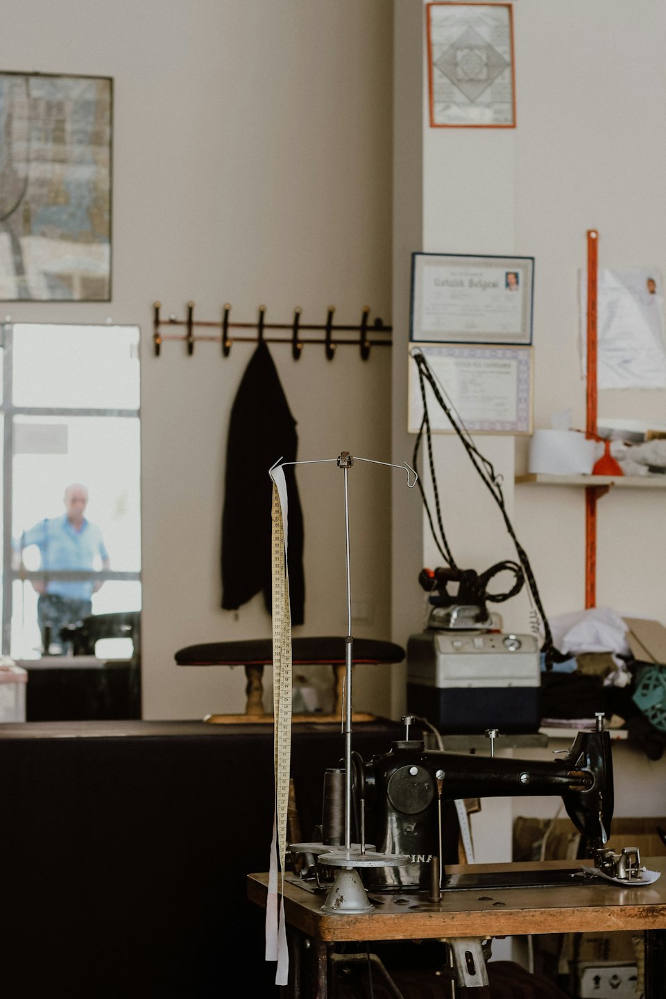 Tailor's workshop with a sewing machine and measuring tape.